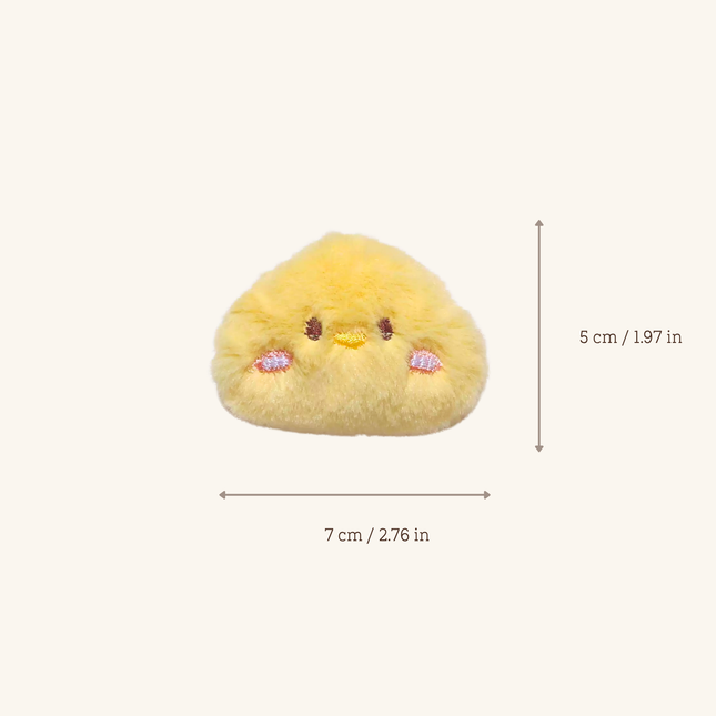 A small yellow plush character toy centered on a light beige background, with measurement arrows and text showing dimensions of 7 cm wide by 5 cm high.