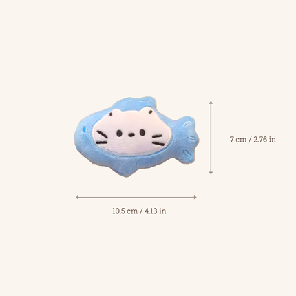 A small plush fish-shaped accessory with a white cat face on a light blue body, shown on a plain light beige background with dimension arrows and text indicating 10.5 cm by 7 cm.