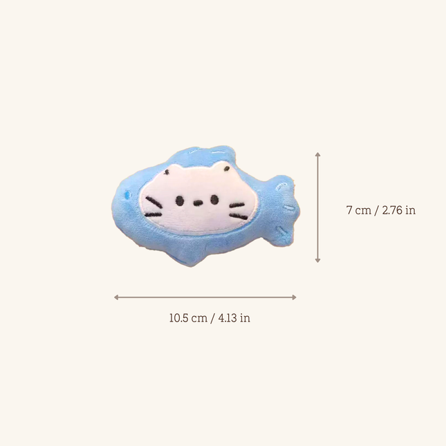 A small plush fish-shaped accessory with a white cat face on a light blue body, shown on a plain light beige background with dimension arrows and text indicating 10.5 cm by 7 cm.