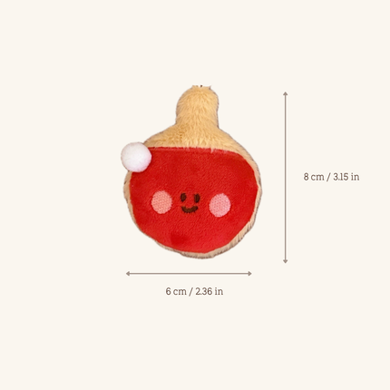 A small plush toy shaped like a red and beige fruit or squash with a cute embroidered face, shown on a light beige background with dimension arrows and text indicating 6 cm width and 8 cm height.