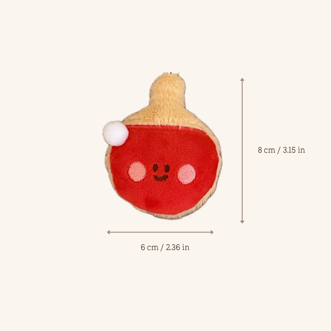 A small plush toy shaped like a red and beige fruit or squash with a cute embroidered face, shown on a light beige background with dimension arrows and text indicating 6 cm width and 8 cm height.