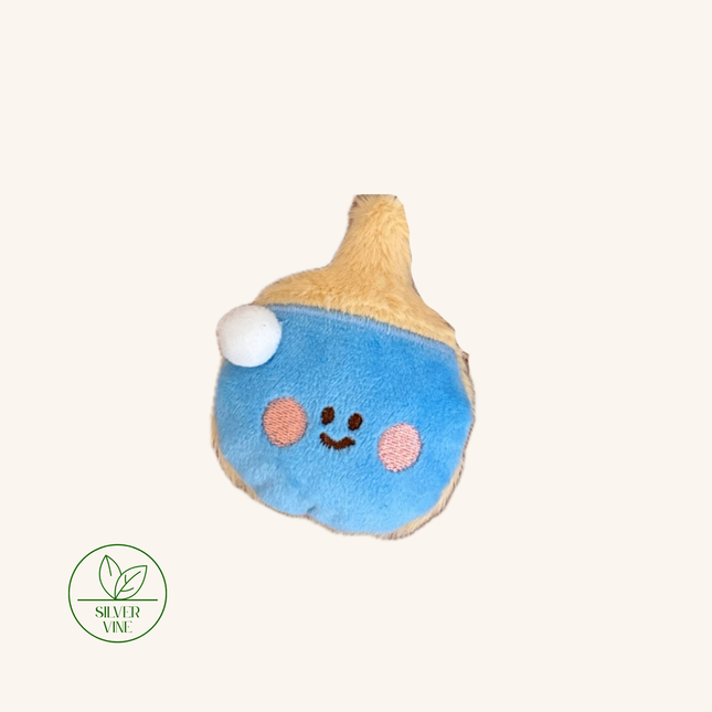A cute plush pillow shaped like a blue acorn with a smiling face, pink cheeks, and a tan top, shown on a light cream background with a 'Silver Vine' logo in the bottom-left corner.