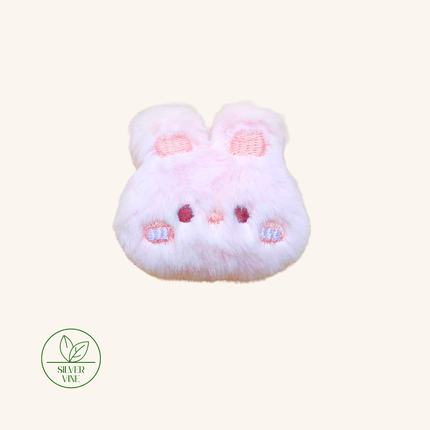 A light pink fluffy bunny-shaped hair accessory with embroidered details, shown on a solid cream background with a 'Silver Vine' brand logo in the bottom-left corner.