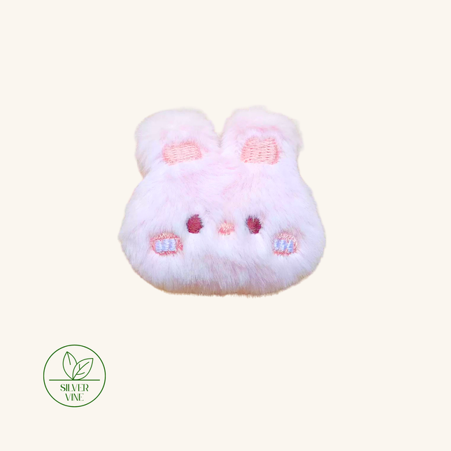 A light pink fluffy bunny-shaped hair accessory with embroidered details, shown on a solid cream background with a 'Silver Vine' brand logo in the bottom-left corner.