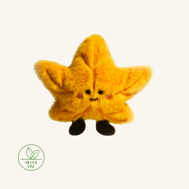 A yellow fuzzy star-shaped plush toy with a cute embroidered face and small black feet, centered on a plain light background. A green 'Silver Vine' sign is visible in the lower-left corner.