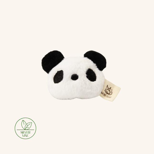 A plush panda head hair accessory in black and white faux fur, featuring a small beige fabric tag with a cat logo and a green 'Silver Vine' brand seal in the lower-left corner, set against a solid cream background.